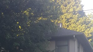 A two-story building with a flat roof and a small balcony on the second floor. There is a street sign indicating 'Fremont Ave N' and a mailbox on the sidewalk.