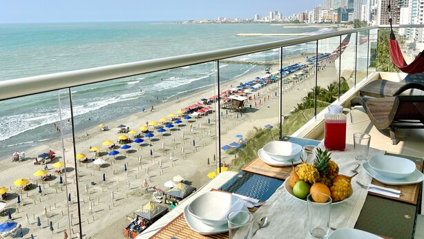 Un balcón con vista a la playa y al horizonte de la ciudad.