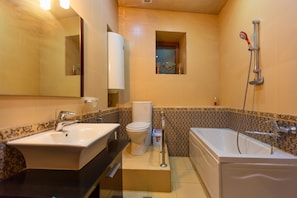 Une salle de bain avec un lavabo, des toilettes et une baignoire.