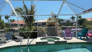 A pool area with a hot tub, lounge chairs, and a covered seating area. - A twist of tropical passion - SW Cape (south facing) with fully Inclusive rates (Cape Coral)