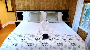 Un letto rifatto con cura, con una coperta a motivi floreali e due cuscini.