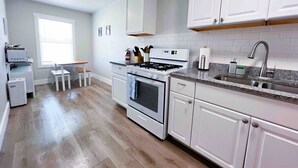A kitchen with white cabinets, a granite countertop, and a stainless steel sink.
