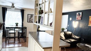 Un espace de vie compact comprenant une kitchenette, un coin repas et un coin salon.