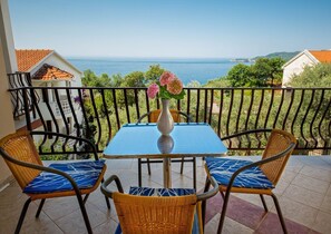 A balcony with a table and chairs, overlooking a coastal view. - Great located apartment in Przno, 5 min from the beach. (Пржно)