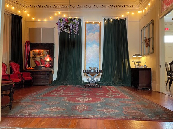 A room with a patterned rug, a globe on a stand, and a painting on the wall. - Bywater Wonderland, 2 blocks to the river, close to many good things! (New Orleans)