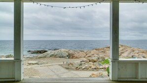 A covered outdoor area with a view of the sea and rocky shoreline. - Historic Cottage w/ Beautiful Oceanfront View (Marshfield)