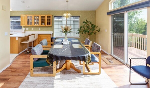 Un coin repas avec une table ronde, des chaises et une grande fenêtre.