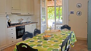 A kitchen with a dining table, chairs, and a view of the outdoors.