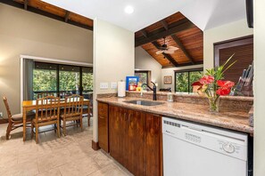 Enjoy meals in the kitchen with a dishwasher and dining area through the glass door.