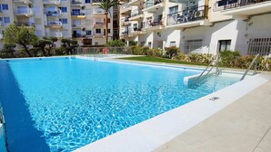 A rectangular swimming pool with clear blue water, surrounded by a tiled deck and metal poolside railings. - AP368 - Coronado 67 (Nerja)