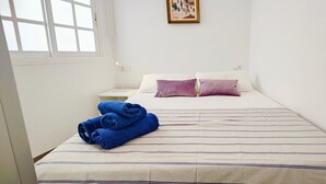 A hotel room with a bed, two pillows, a nightstand with a lamp, and a window. - AP368 - Coronado 67 (Nerja)