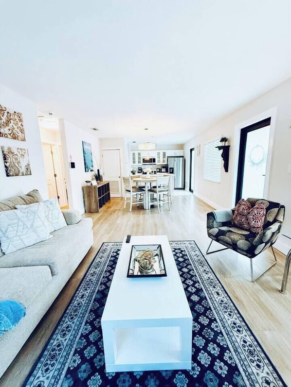 A modern living room with a sofa, a coffee table, and a patterned rug.