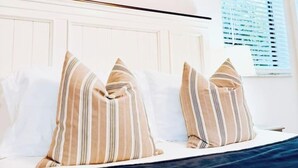 A bedroom with a bed, striped pillows, and two framed pictures on the wall. - Quiet retreat near Coconut Grove + free parking (Miami)