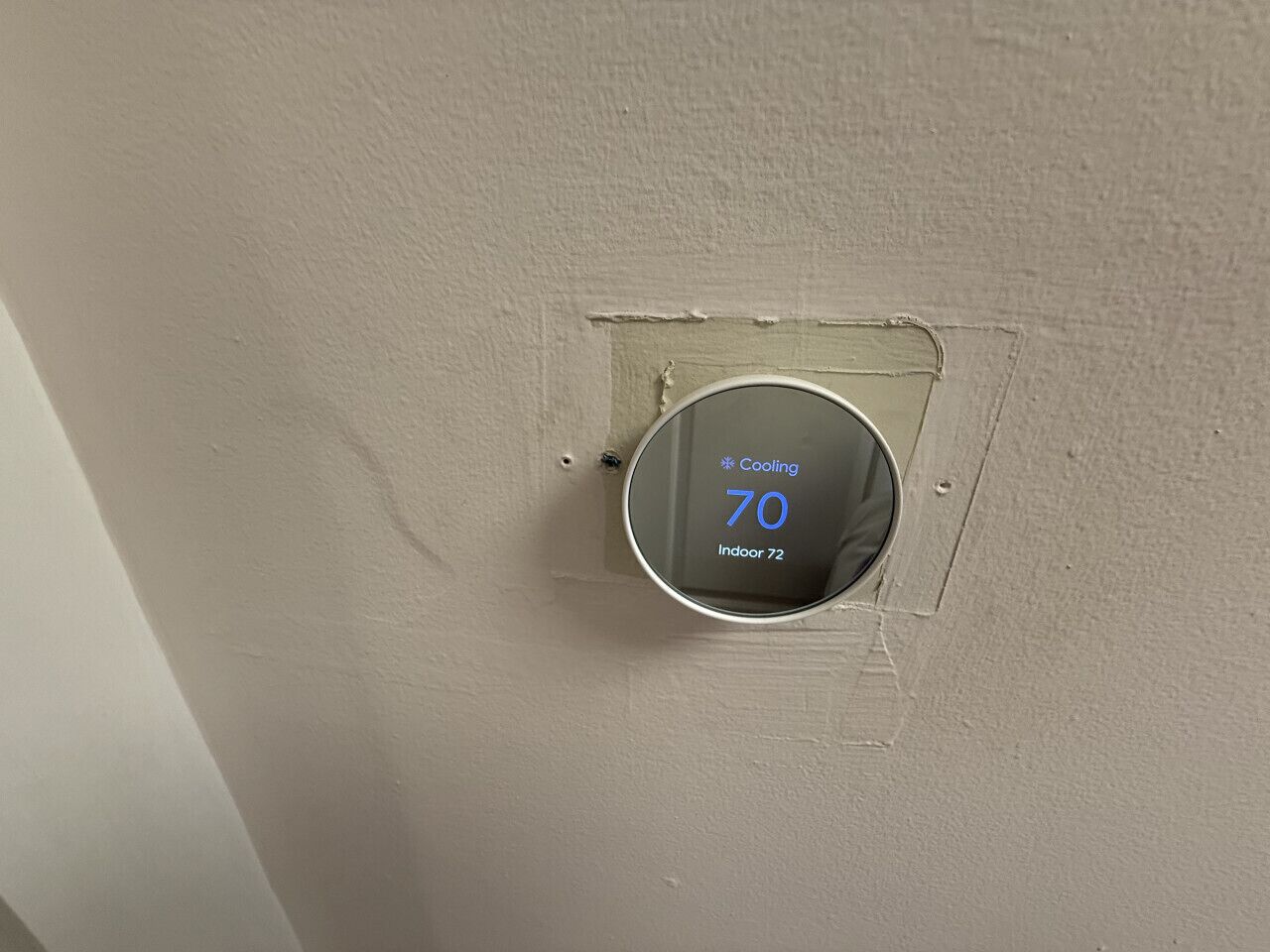 Termostato ajustado a 21 grados Celsius con función de enfriamiento, que indica la temperatura interior.