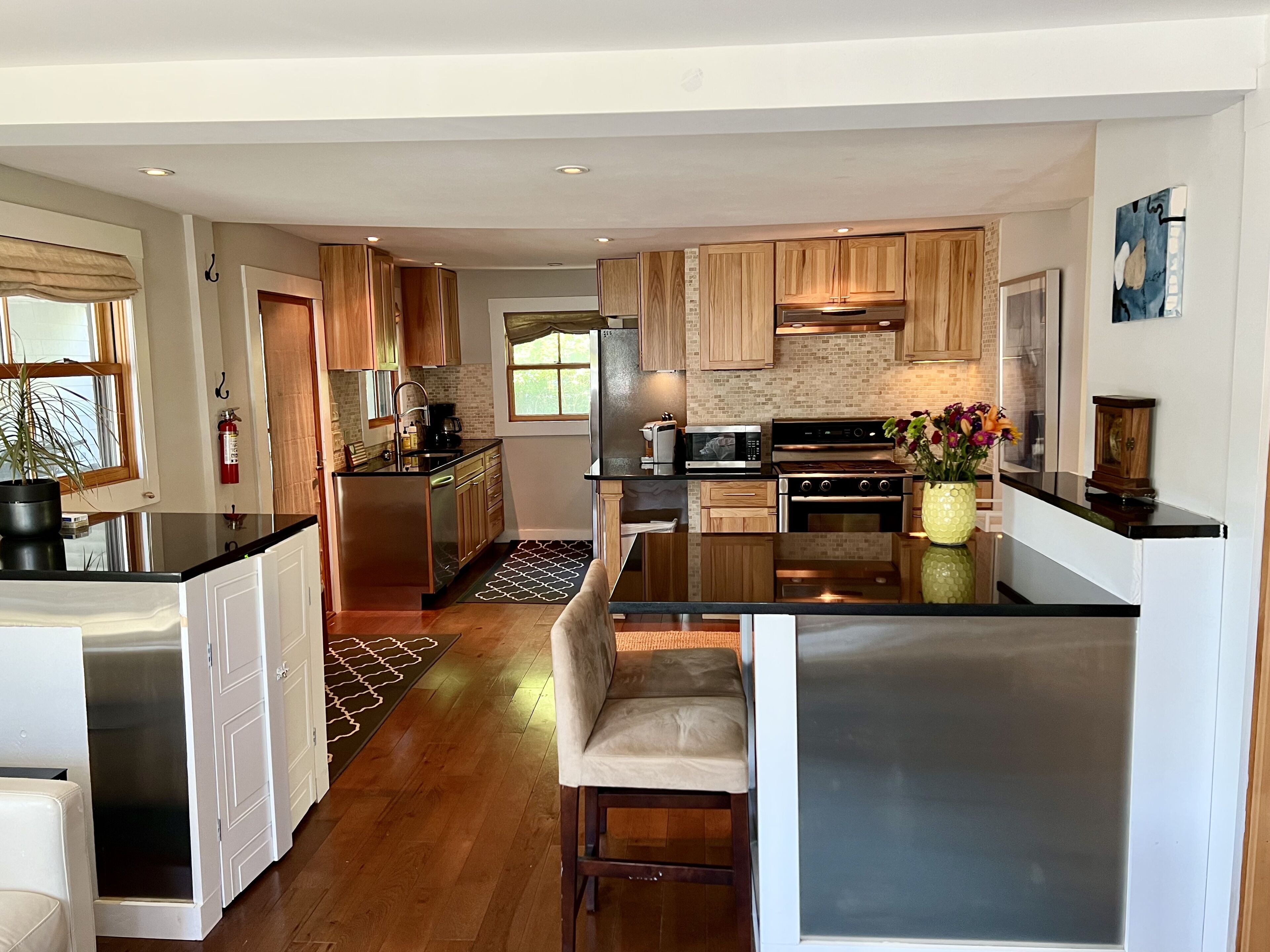 Una cocina moderna con armarios de madera, electrodomésticos de acero inoxidable y una isla central.