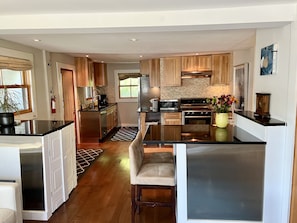 Une cuisine moderne avec des meubles en bois, des appareils électroménagers en acier inoxydable et un îlot central.