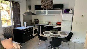 Eine kompakte Küche mit Essbereich, ausgestattet mit einer Mikrowelle, einem Backofen und einem kleinen Kühlschrank.