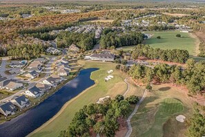 Residents enjoy scenic views of a tranquil lake surrounded by a golf course and lush trees.