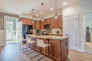 Enjoy casual dining and cooking in this kitchen with a central island, appliances, and ample countertop space.