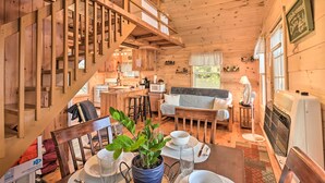 Ein Holzblockhaus-Interieur mit Essbereich, Küche und einer Treppe.