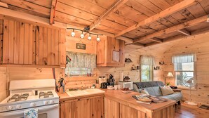 Eine gemütliche Küchenzeile im Blockhausstil mit Holzschränken, einem Herd und einem Spülbecken.