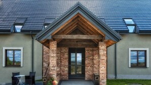 A building with a brick facade, a wooden gable, and a door with glass panels. - Residence Szary (Michalowice)
