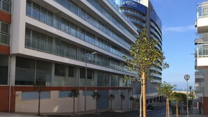 A modern building with multiple floors, large windows, and a flat roof. - Galante Beach Apartment 2 (Figueira da Foz)