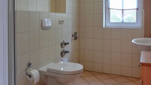 A bathroom with a toilet, sink, and shower. - Apartment T7 - 2-room apartment for 4 pers. on the upper floor. Close to the beach (Graal-Müritz)