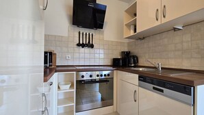 Una cocina moderna con horno empotrado, lavavajillas y cafetera.