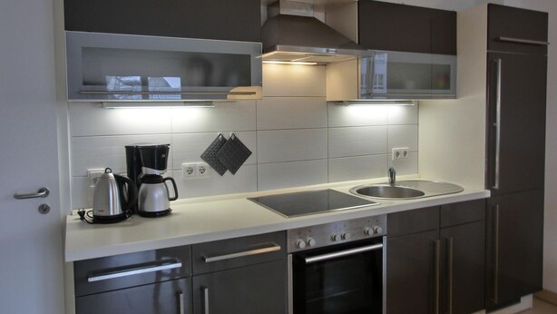Una cocina moderna con electrodomésticos de acero inoxidable, horno integrado y microondas.