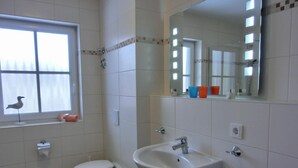 Un baño con inodoro, lavabo y ventana.