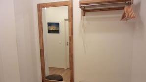 Un baño con un espejo de marco de madera, un taburete pequeño y un perchero para toallas.