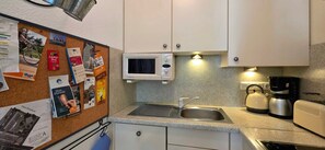 Eine Küche mit Mikrowelle, Wasserkocher und Kaffeemaschine.