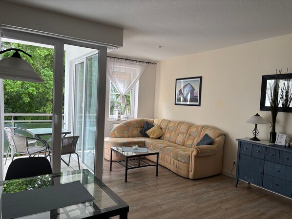 A living room with a sofa, a table, a lamp, and a cabinet.