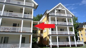 A multi-story residential building with balconies and a central entrance.