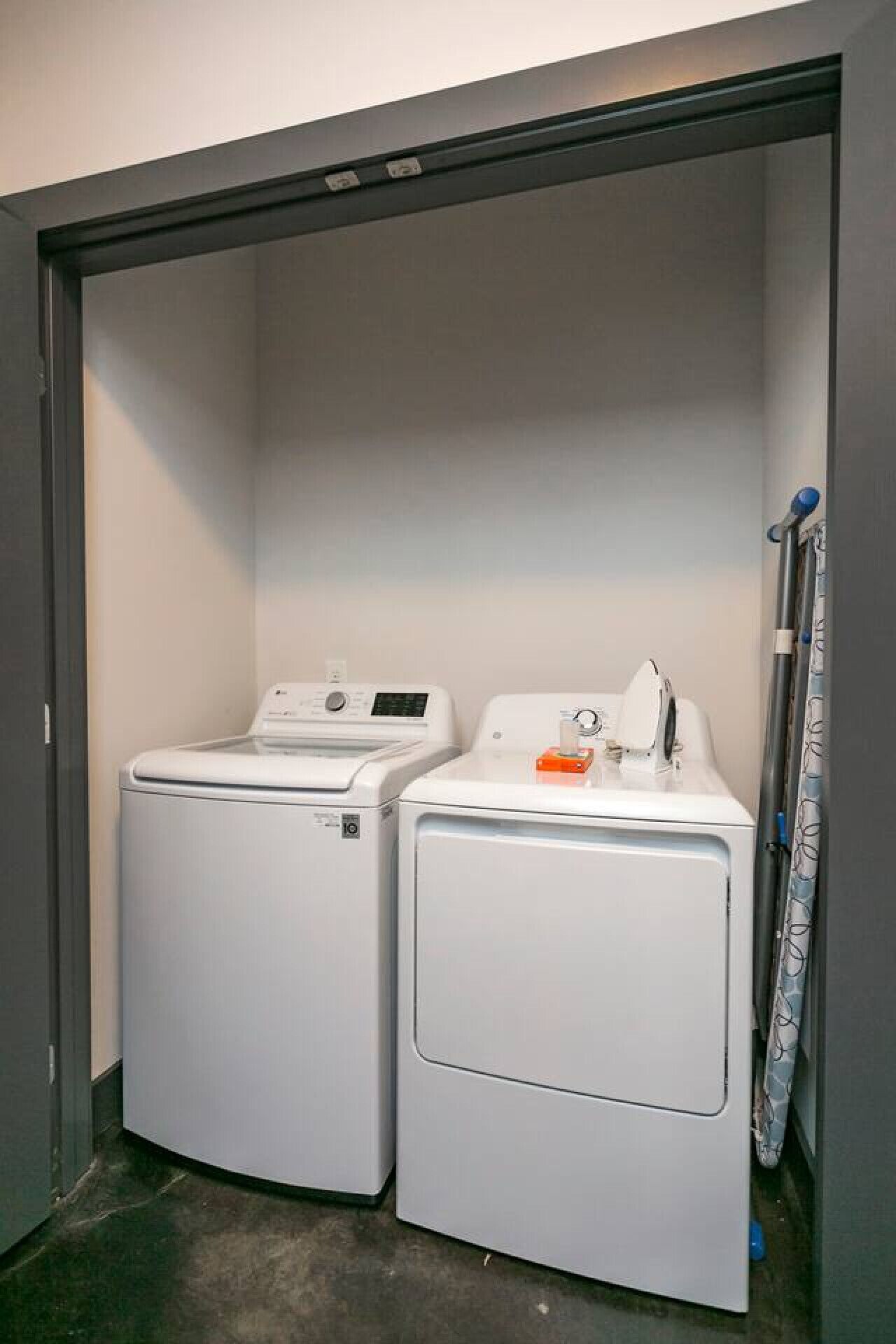 Une buanderie équipée de deux machines à laver à chargement frontal et d’un sèche-linge.