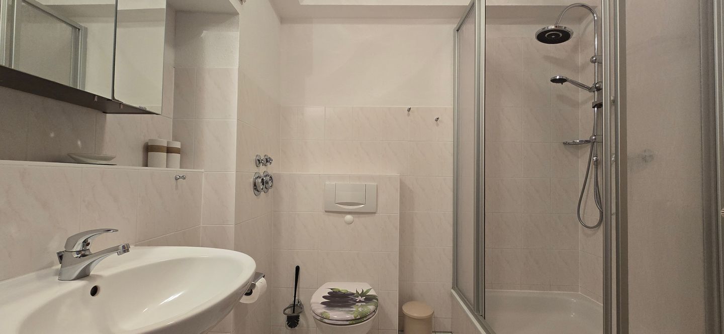 A bathroom with a sink, toilet, and shower.