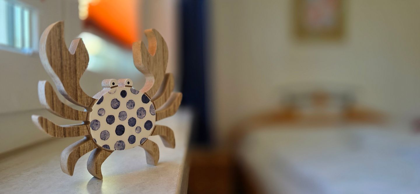 Een houten krab decoratie op een tafel.