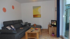 Een woonkamer met een bank, salontafel en een televisie.