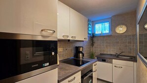 Una cucina moderna con forno a microonde Zanker integrato, macchina del caffè e lavastoviglie.