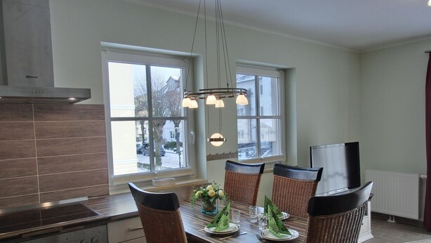 A modern kitchen with a dining area, large windows, and a built-in oven. - Apartment L32 - "Lütte Möw" - 2-room apartment for 4 people on the 1st floor with WiFi (Graal-Müritz)