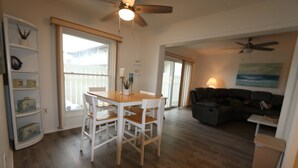 A spacious living area with a wooden floor, a dining table with chairs, a black leather sofa, and a ceiling fan. - ABOUT 5 BLOCKS FROM THE BEACH/ OCEAN / NORTH END OF BOARDWALK (Ocean City)