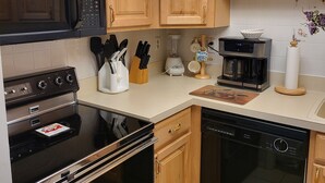 A kitchen with wooden cabinets, a microwave, a stove, a dishwasher, and a coffee maker. - ABOUT 5 BLOCKS FROM THE BEACH/ OCEAN / NORTH END OF BOARDWALK (Ocean City)