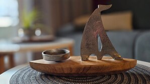 A wooden table with a metal sculpture of a bear and a small bowl. - Apartment L28 - 2-room apartment on the 2nd floor, approx. 45 m² for 4 persons with WLAN (Graal-Müritz)