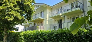 Un edificio residenziale a più piani con balconi, circondato da una vegetazione lussureggiante.