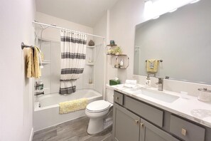 Une salle de bain moderne avec une baignoire, des toilettes et un meuble-lavabo.