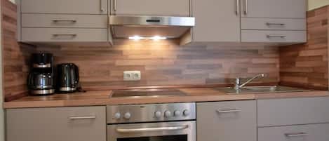 Een koelkast, een oven, een kookplaat, een vaatwasser