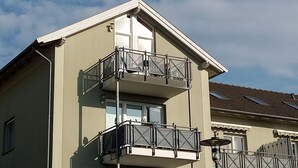 A two-story building with a balcony on the second floor.