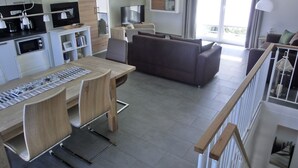 Een moderne keuken met een eethoek, een bank en een trap.