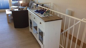Quarto com cozinha compacta, espaço de refeições e vista para o exterior.